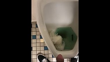 Asian boy pissing in a urinal